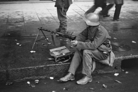 Unruhen von Genf 1932: Soldat mit Gewehr am Strassenrand sitzend